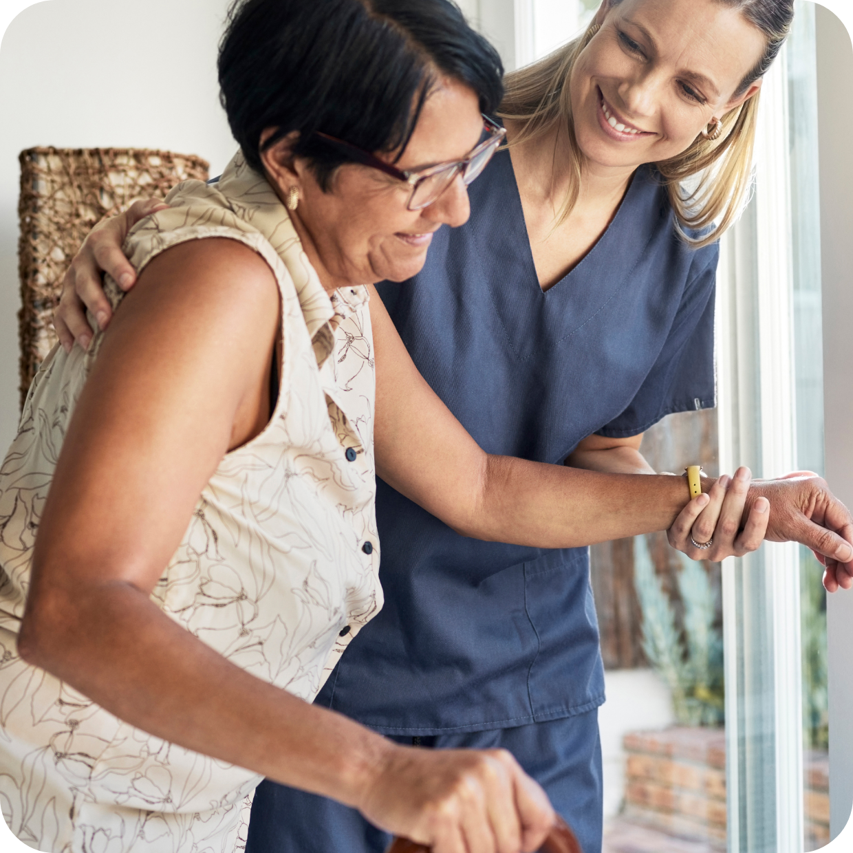 Nurse assisting woman with walking stick